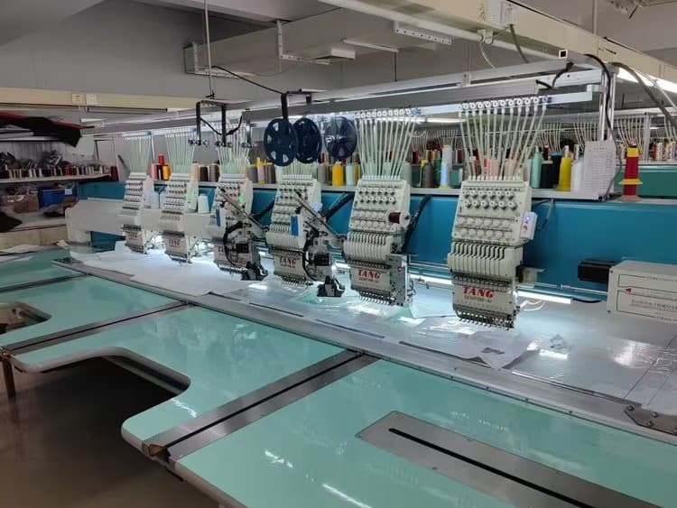 Row of multi-head embroidery machines in operation