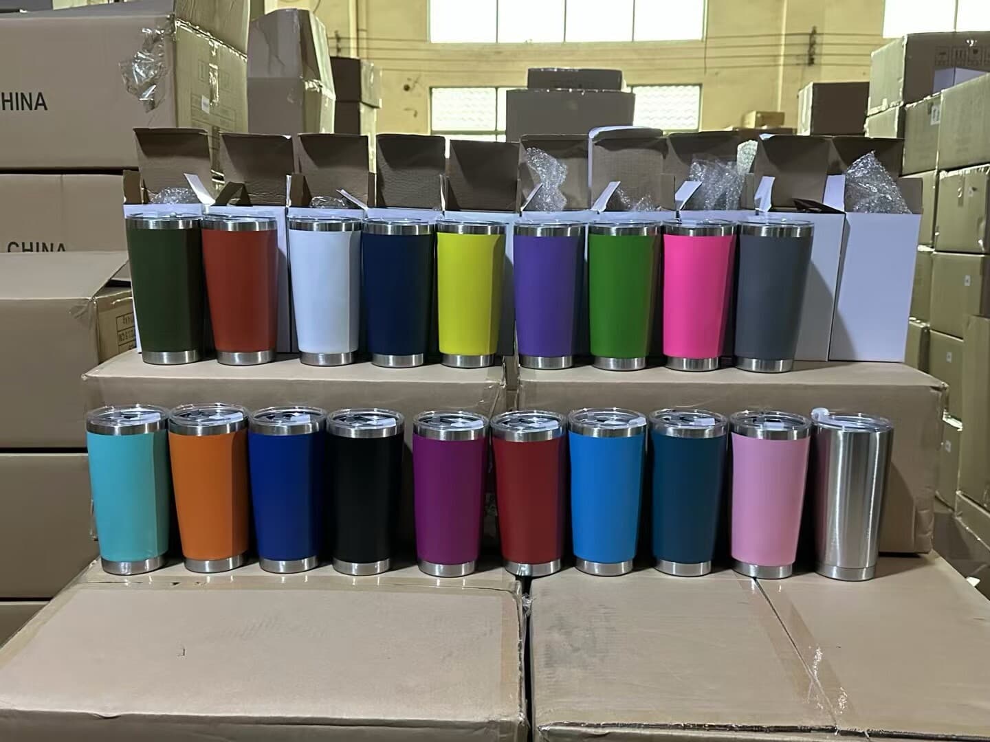Rows of custom-colored tumblers packed and ready to ship from a factory floor